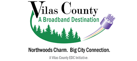 Logo for Vilas County, featuring green trees, a broadband cable, and the tagline: Northwoods Charm. Big City Connection. Text below reads, A Vilas County EDC Initiative.