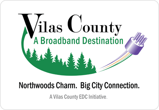 Logo for Vilas County, labeled A Broadband Destination, with green pine trees, a fiber optic cable, and the slogan Northwoods Charm. Big City Connection. Text notes it is a Vilas County EDC initiative.